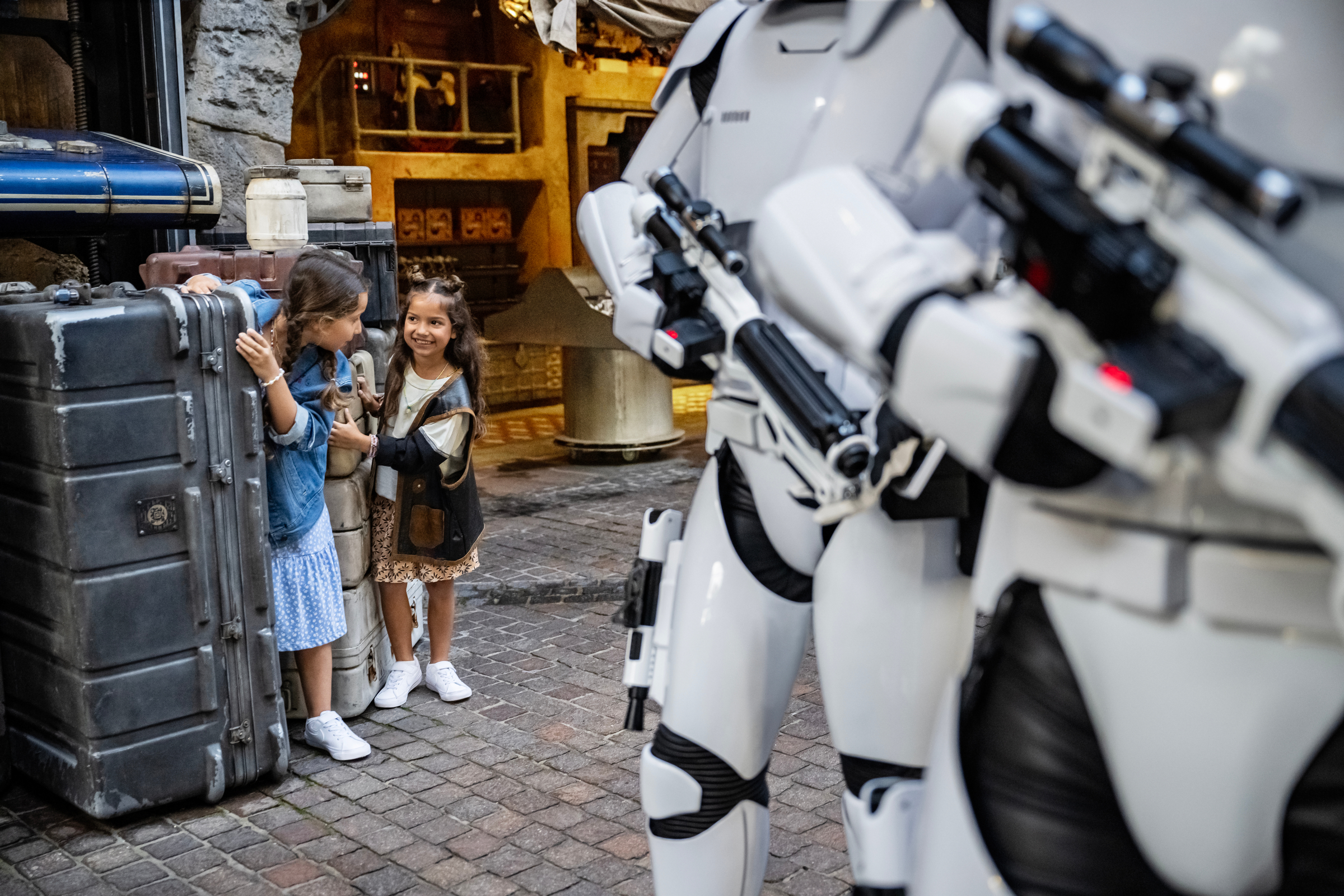 little girls hiding behind corner from Star Wars Stormtroopers in Star Wars Land at DIsney