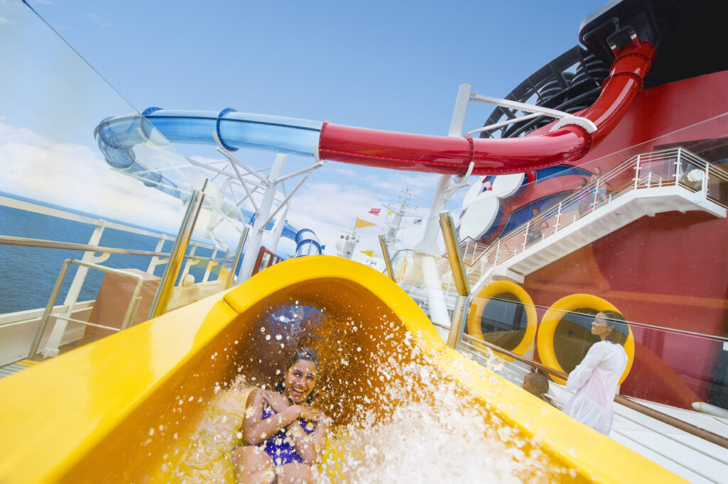 girl smiling coming out of Aquadunk slide tube on DCL Magic
