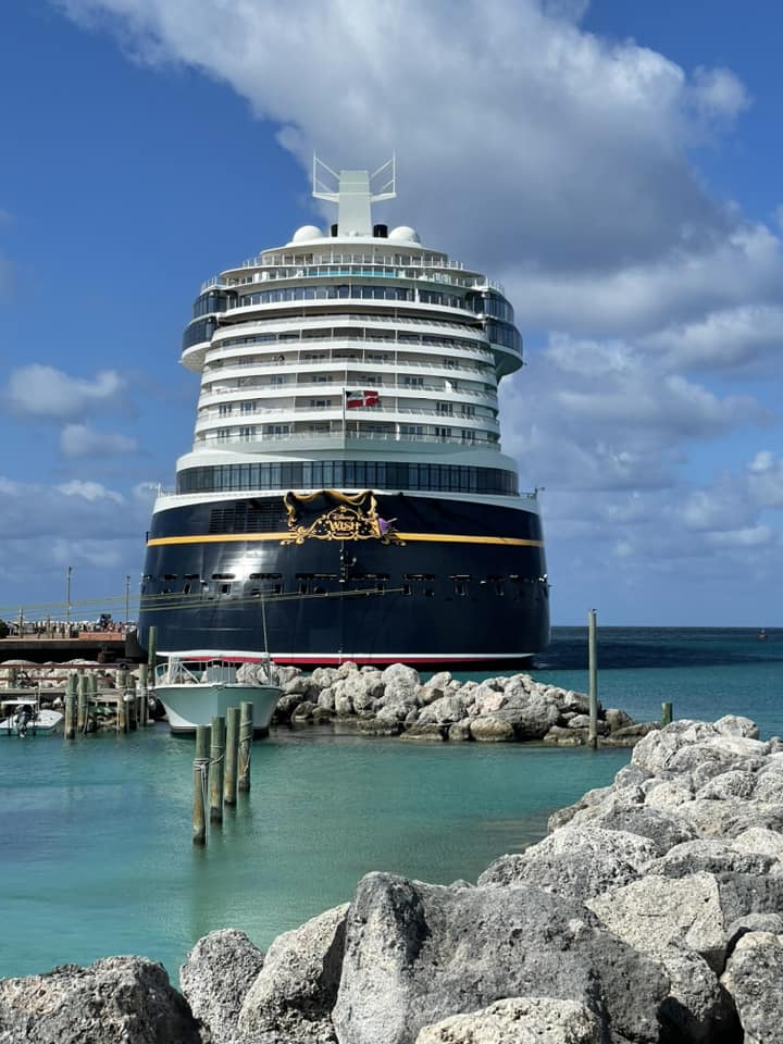 Stern of DCL Disney Wish docked in port at Castaway Cay