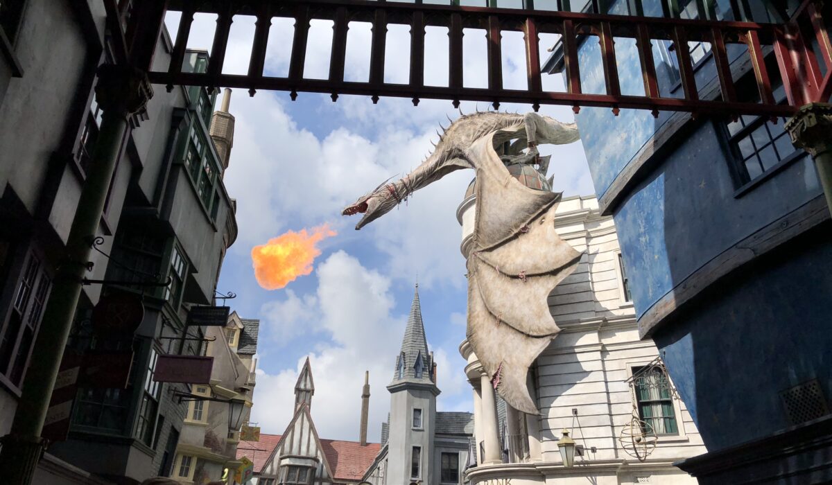 Gringotts Dragon perched on top of the Gringotts Bank in Diagon Alley breathing fire with excited guests taking pictures at Universal Orlando Florida