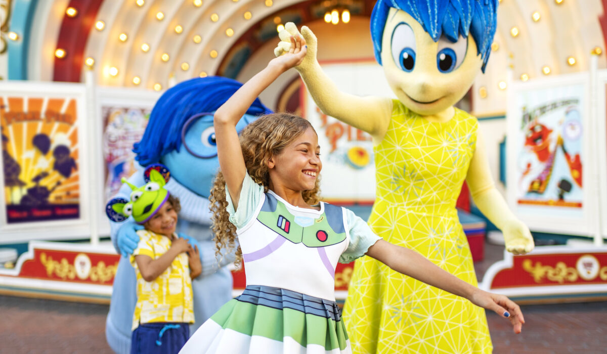 Pixar character Jot twirling little girl at Disneyland Pixar Fest