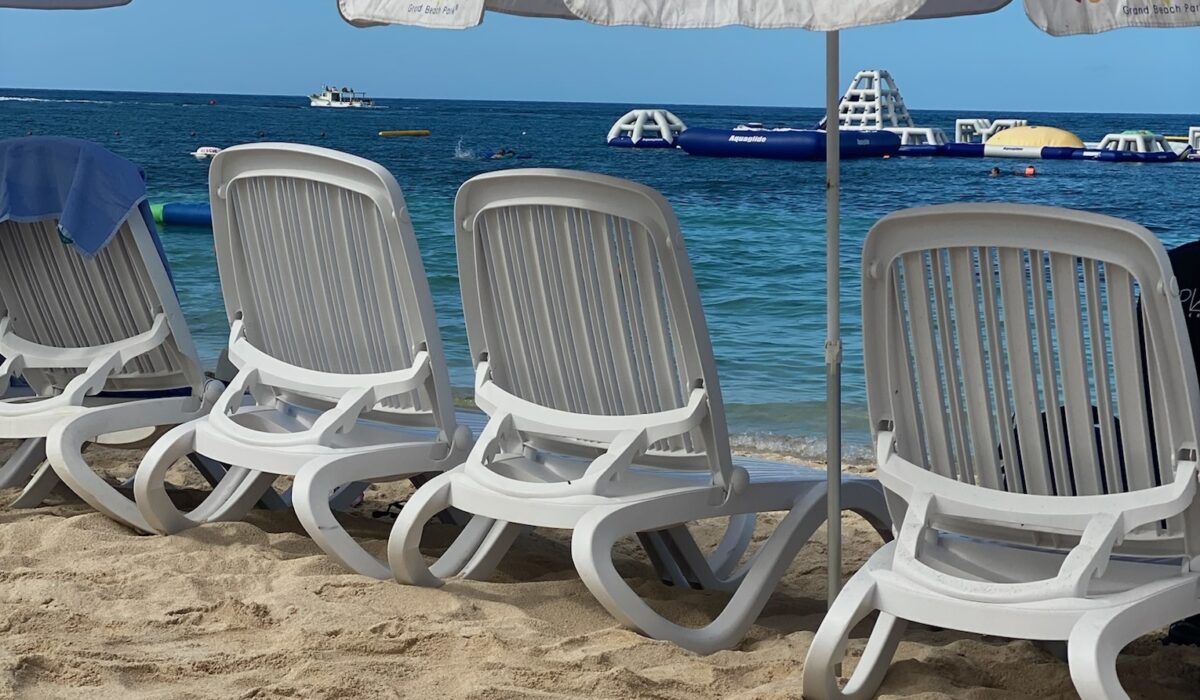 blue ocean water with beach chairs and umbrella on beach Royal Caribbean cruise excursion in Playa Mia Cozumel