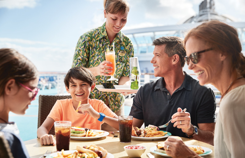 family eating a meal at a table onboard the deck of a princess cruise ship