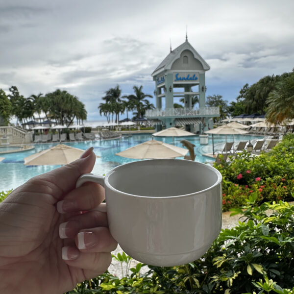 coffee cup at breakfast overlooking a resort pool