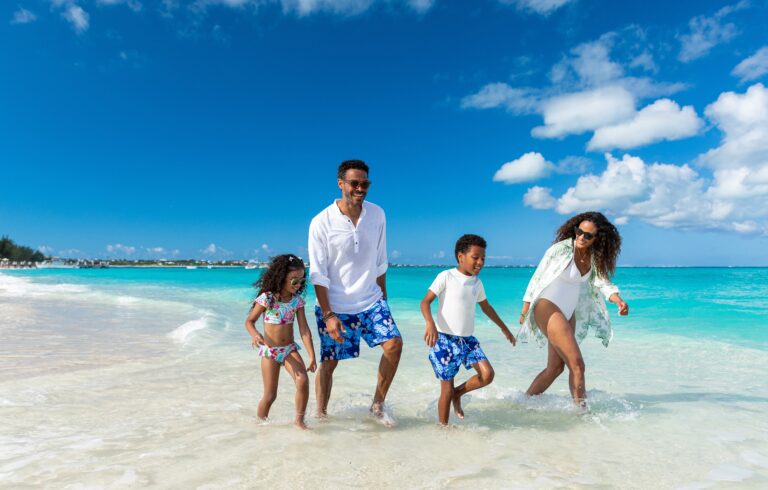 family holding hands walking on beach at Turks and Caicos